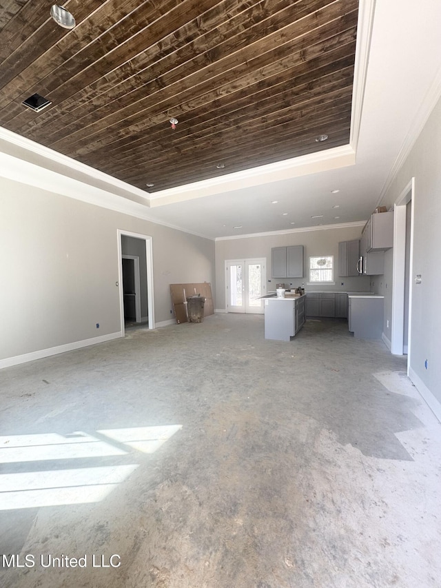 unfurnished living room featuring wooden ceiling, baseboards, a raised ceiling, and ornamental molding