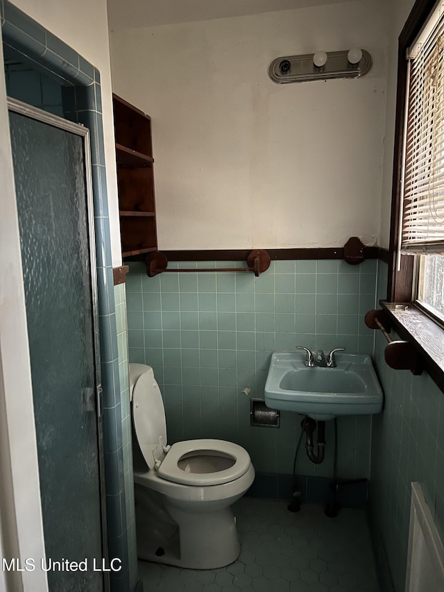 2643 Pinebrook Dr, Jackson, MS 39212 - bathroom with tile walls, toilet, a stall shower, tile patterned floors, and a wainscoted wall