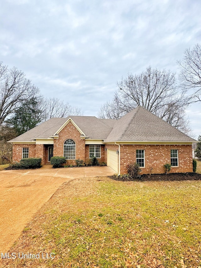 ranch-style house featuring a garage, brick siding, concrete driveway, roof with shingles, and a front yard