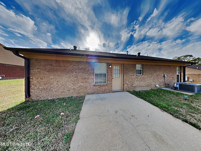 1764 Dorchester Dr, Southaven, MS 38671 - back of house featuring a patio area, central AC unit, brick siding, and a yard