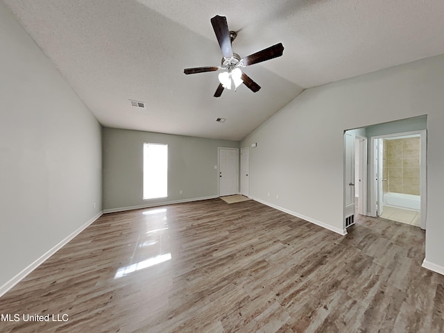 1764 Dorchester Dr, Southaven, MS 38671 - spare room featuring a ceiling fan, wood finished floors, vaulted ceiling, a textured ceiling, and baseboards