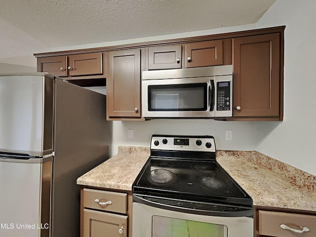 1764 Dorchester Dr, Southaven, MS 38671 - kitchen featuring appliances with stainless steel finishes, light countertops, a textured ceiling, and dark brown cabinetry