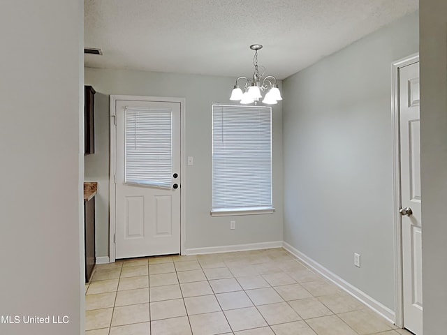 1764 Dorchester Dr, Southaven, MS 38671 - unfurnished dining area featuring a chandelier, light tile patterned floors, baseboards, and a textured ceiling