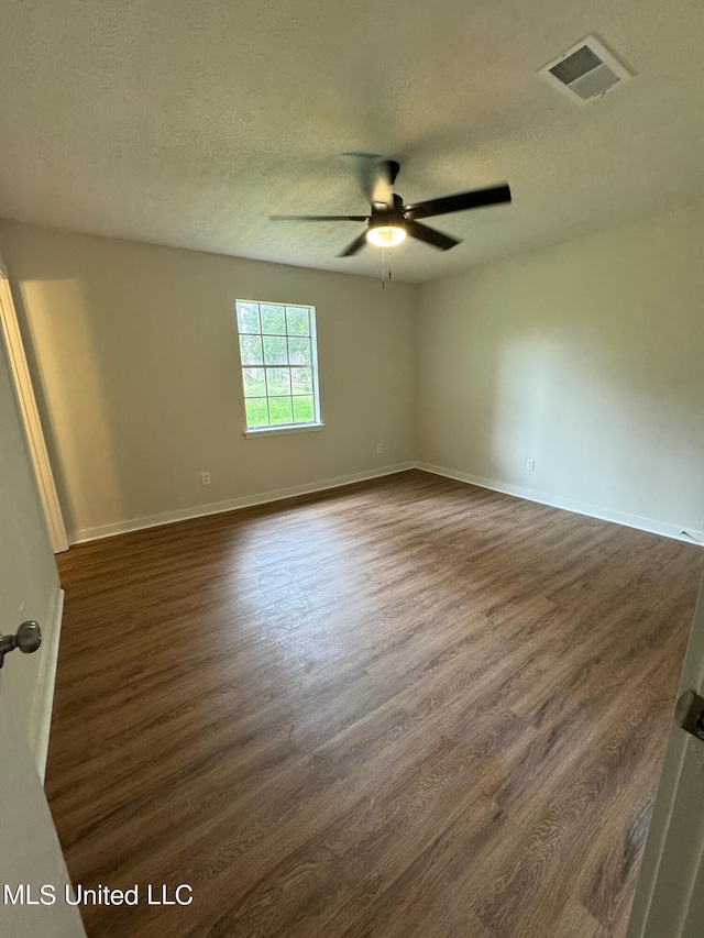 empty room featuring dark wood-type flooring, a textured ceiling, and ceiling fan