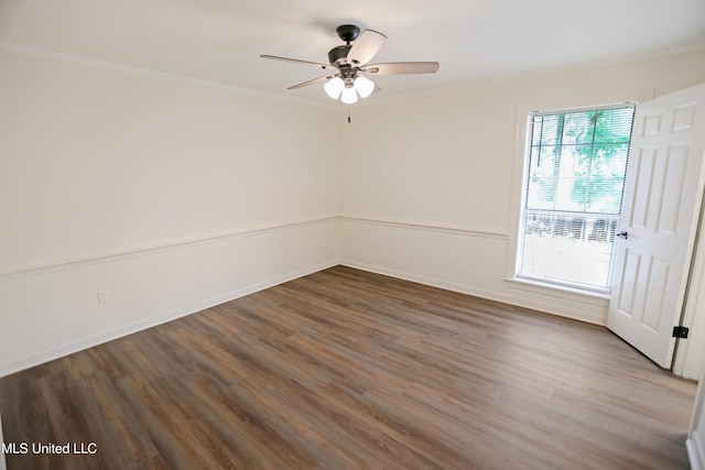 spare room with baseboards, ornamental molding, a ceiling fan, and wood finished floors