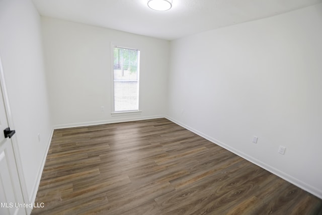 unfurnished room featuring dark wood-style floors and baseboards