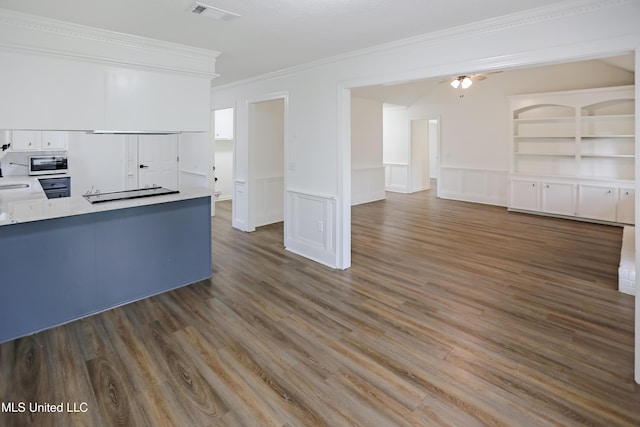kitchen featuring white cabinets, visible vents, stainless steel microwave, and wood finished floors