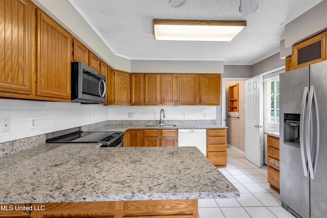 7105 Mandarin Dr, Biloxi, MS 39532 - kitchen with appliances with stainless steel finishes, a textured ceiling, light tile patterned floors, decorative backsplash, and a peninsula