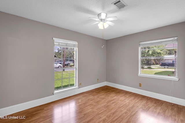 7105 Mandarin Dr, Biloxi, MS 39532 - spare room with wood finished floors, plenty of natural light, a ceiling fan, and a textured ceiling