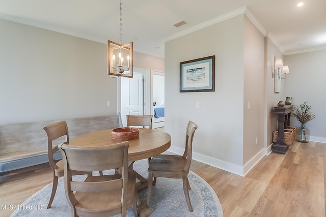 dining area featuring light hardwood / wood-style floors, a notable chandelier, and ornamental molding