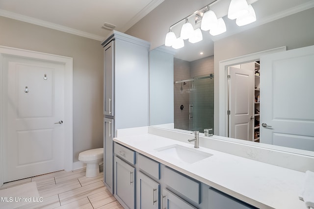 bathroom featuring vanity, toilet, an enclosed shower, and ornamental molding