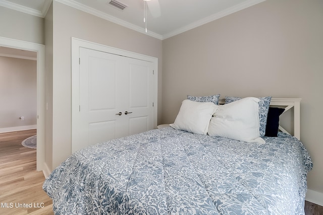 bedroom featuring ceiling fan, ornamental molding, and a closet