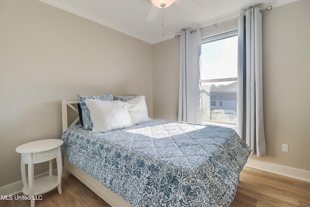 bedroom with ceiling fan and hardwood / wood-style flooring