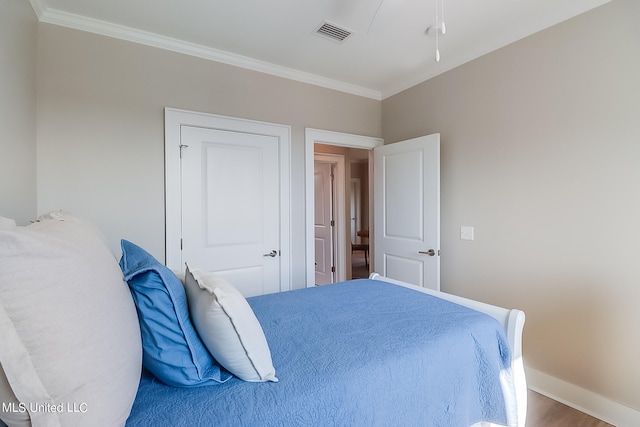 bedroom with wood-type flooring and ornamental molding