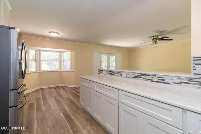 13128 Hanover Dr, Ocean Springs, MS 39564 - kitchen with stainless steel fridge, decorative backsplash, a ceiling fan, dark wood-style flooring, and light countertops