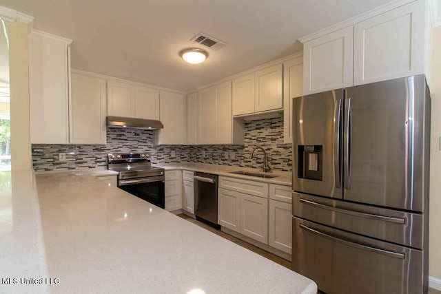 13128 Hanover Dr, Ocean Springs, MS 39564 - kitchen featuring stainless steel appliances, under cabinet range hood, decorative backsplash, and white cabinets