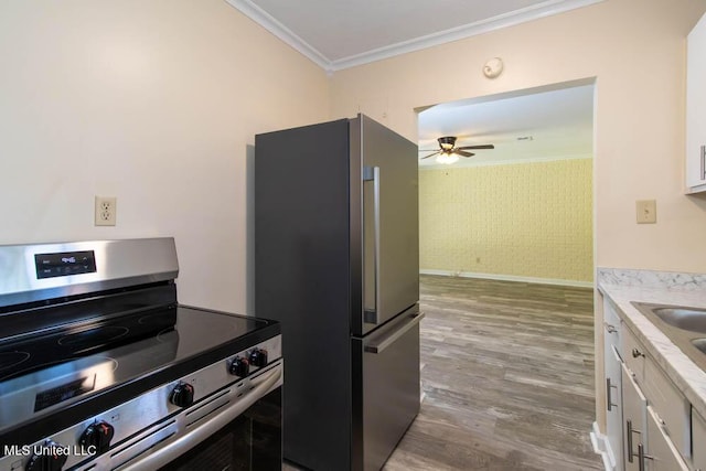 13128 Hanover Dr, Ocean Springs, MS 39564 - kitchen with stainless steel appliances, crown molding, white cabinets, light countertops, and wood finished floors