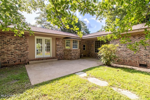 13128 Hanover Dr, Ocean Springs, MS 39564 - rear view of house with french doors, brick siding, a lawn, and a patio