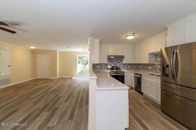 13128 Hanover Dr, Ocean Springs, MS 39564 - kitchen with appliances with stainless steel finishes, ceiling fan, under cabinet range hood, a peninsula, and ornamental molding
