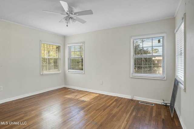 unfurnished room featuring ornamental molding, wood-type flooring, visible vents, and baseboards