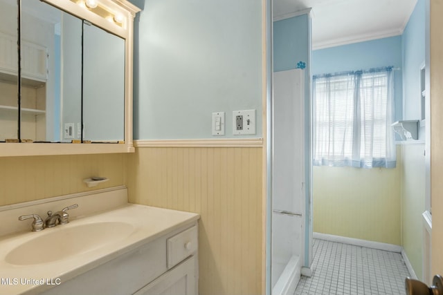 bathroom with tile patterned flooring, a wainscoted wall, crown molding, and vanity