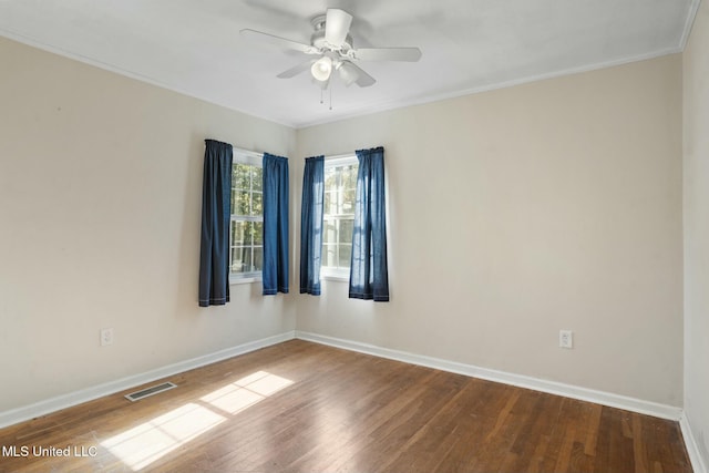 spare room featuring a ceiling fan, baseboards, visible vents, and wood finished floors