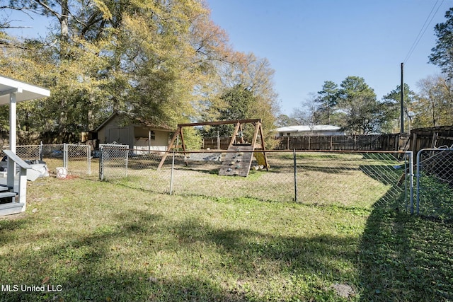 view of yard with an outbuilding, a playground, and a fenced backyard