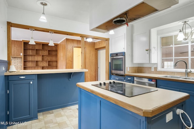 kitchen featuring appliances with stainless steel finishes, a center island, blue cabinets, light floors, and a sink