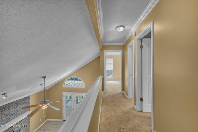 corridor with baseboards, vaulted ceiling, light carpet, ornamental molding, and a textured ceiling