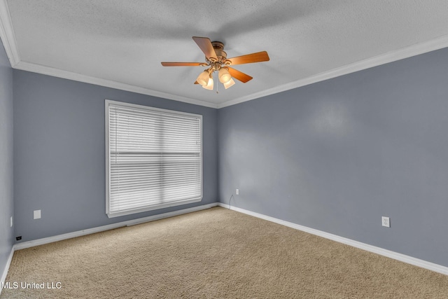 carpeted spare room with ceiling fan, a textured ceiling, baseboards, and ornamental molding