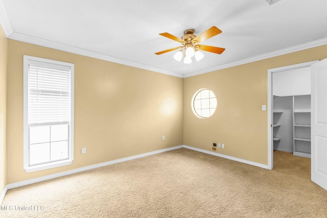 empty room with ceiling fan, baseboards, carpet floors, and ornamental molding