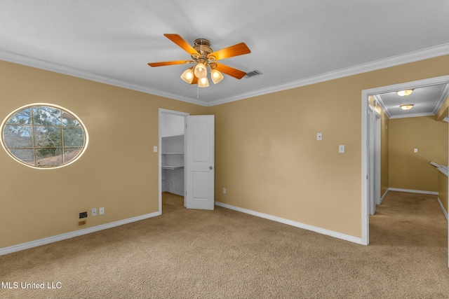 interior space featuring light carpet, visible vents, a spacious closet, and crown molding