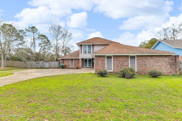 view of front of home with fence, driveway, a shingled roof, a front lawn, and brick siding