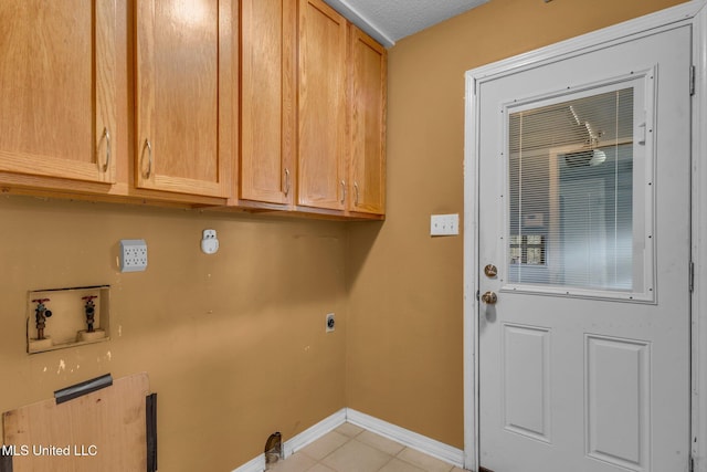 laundry room featuring electric dryer hookup, washer hookup, cabinet space, light tile patterned floors, and baseboards