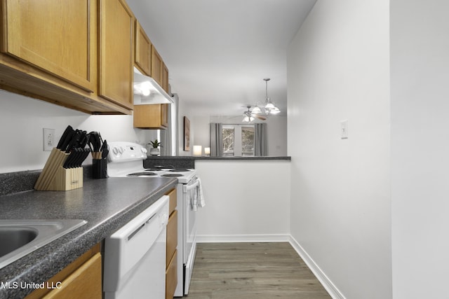 kitchen with sink, white appliances, ceiling fan, hanging light fixtures, and dark hardwood / wood-style flooring