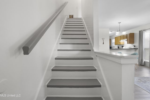 staircase featuring a notable chandelier and hardwood / wood-style floors