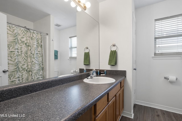 bathroom with toilet, wood-type flooring, and vanity