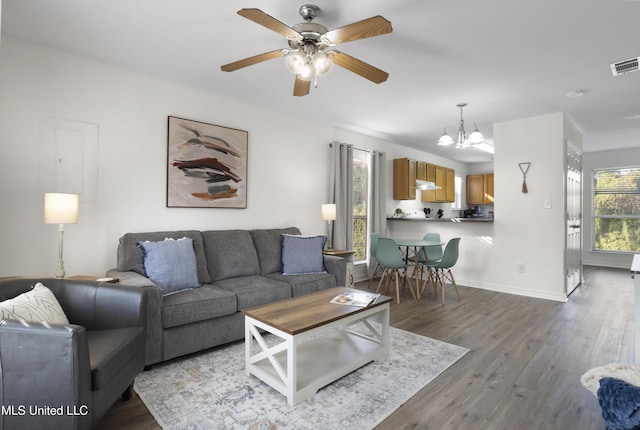 living room featuring ceiling fan with notable chandelier and light wood-type flooring