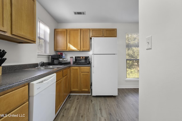 kitchen with white appliances, light wood-type flooring, and sink