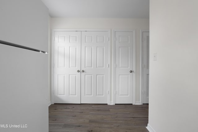 unfurnished bedroom featuring a closet and dark hardwood / wood-style floors