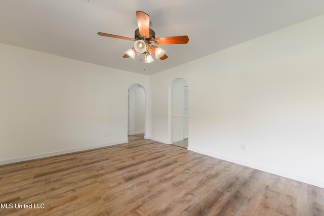 205 Walnut Dr, Ocean Springs, MS 39564 - empty room featuring arched walkways, ceiling fan, and wood finished floors