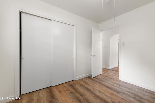 205 Walnut Dr, Ocean Springs, MS 39564 - unfurnished bedroom featuring wood finished floors, arched walkways, and a closet