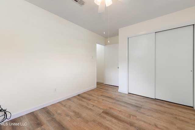 205 Walnut Dr, Ocean Springs, MS 39564 - unfurnished bedroom with wood finished floors, a closet, and a ceiling fan