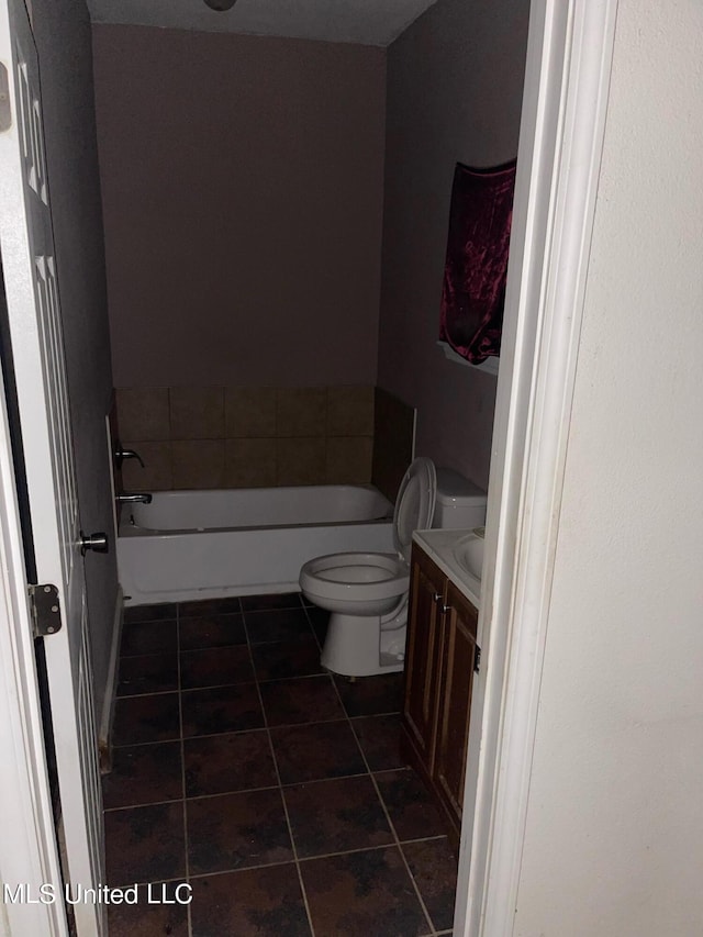 bathroom featuring vanity, toilet, a tub to relax in, and tile patterned floors