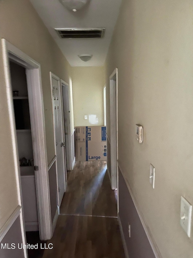 corridor with dark hardwood / wood-style flooring