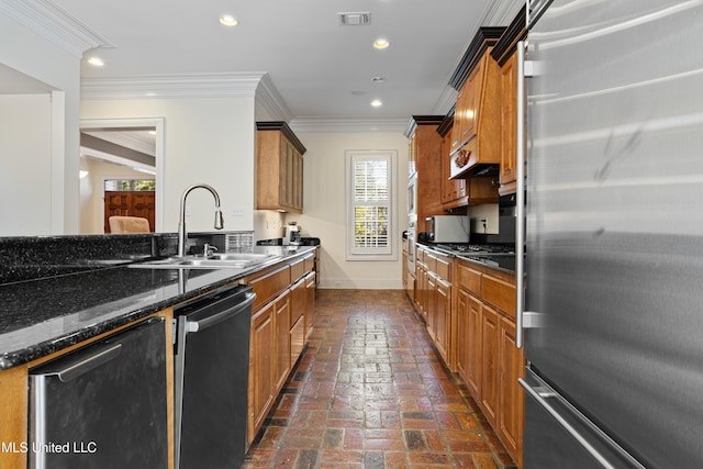 kitchen featuring dark stone counters, crown molding, sink, and stainless steel appliances