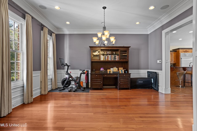 dining space featuring hardwood / wood-style floors, plenty of natural light, ornamental molding, and an inviting chandelier