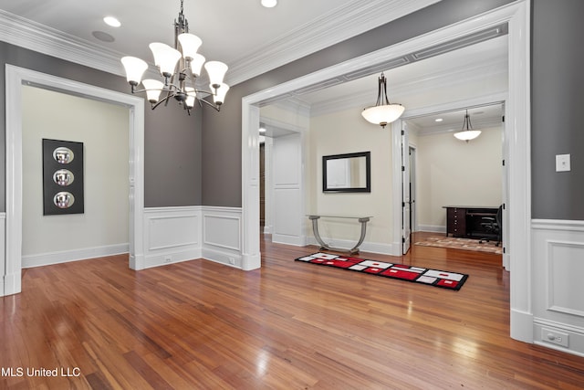 dining area featuring hardwood / wood-style flooring, ornamental molding, and a chandelier