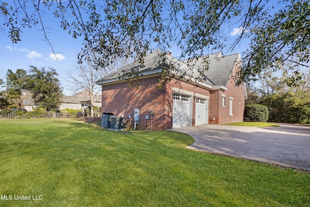 view of side of property featuring a yard, a garage, and central air condition unit