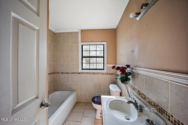 full bath with tile patterned floors, toilet, tile walls, wainscoting, and vanity